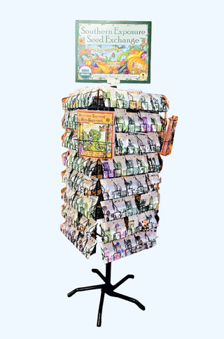 A heavy gauge wire retail display rack designed for seed packets, with decorative signs and multiple panels, spinning on a central pole.